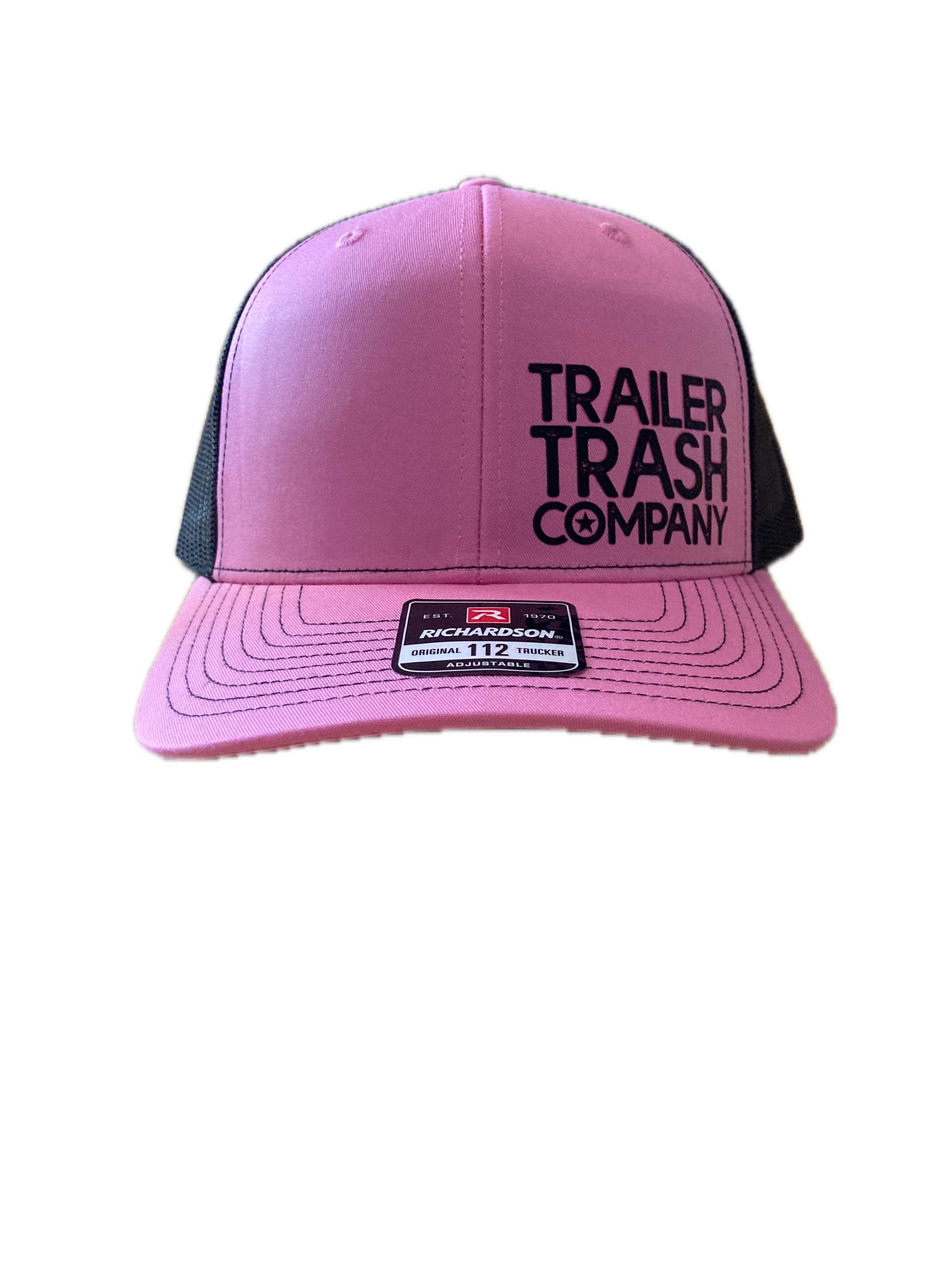 A pink and black trucker hat with 'TRAILER TRASH COMPANY' printed in black on the front panels and a black mesh back, shown against a plain white background.
